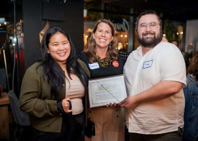 Corrie and the NSLC team holding an award and smiling.