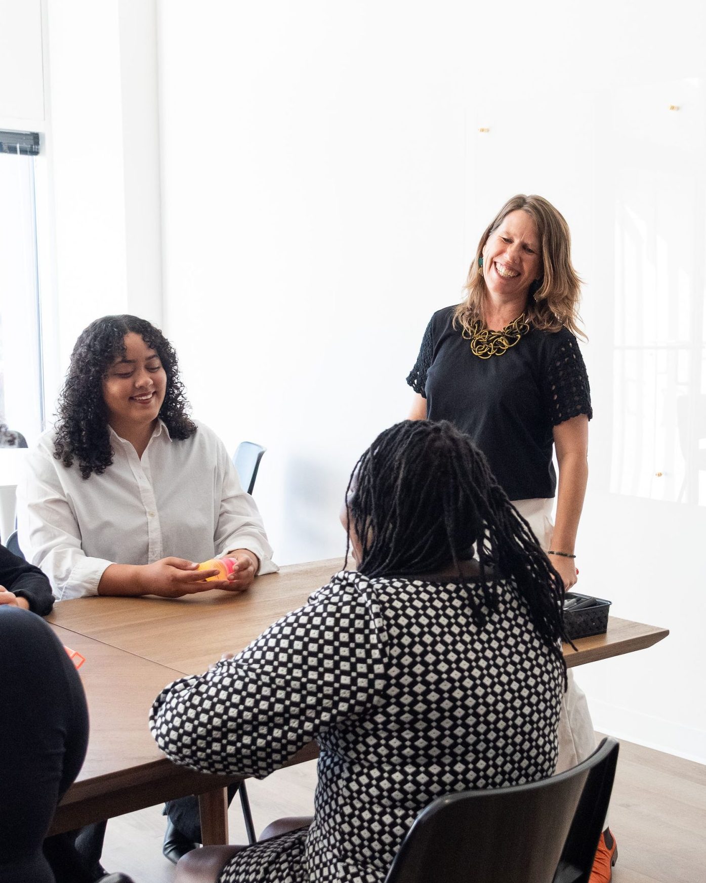 A group of coworkers sit together talking at a table.